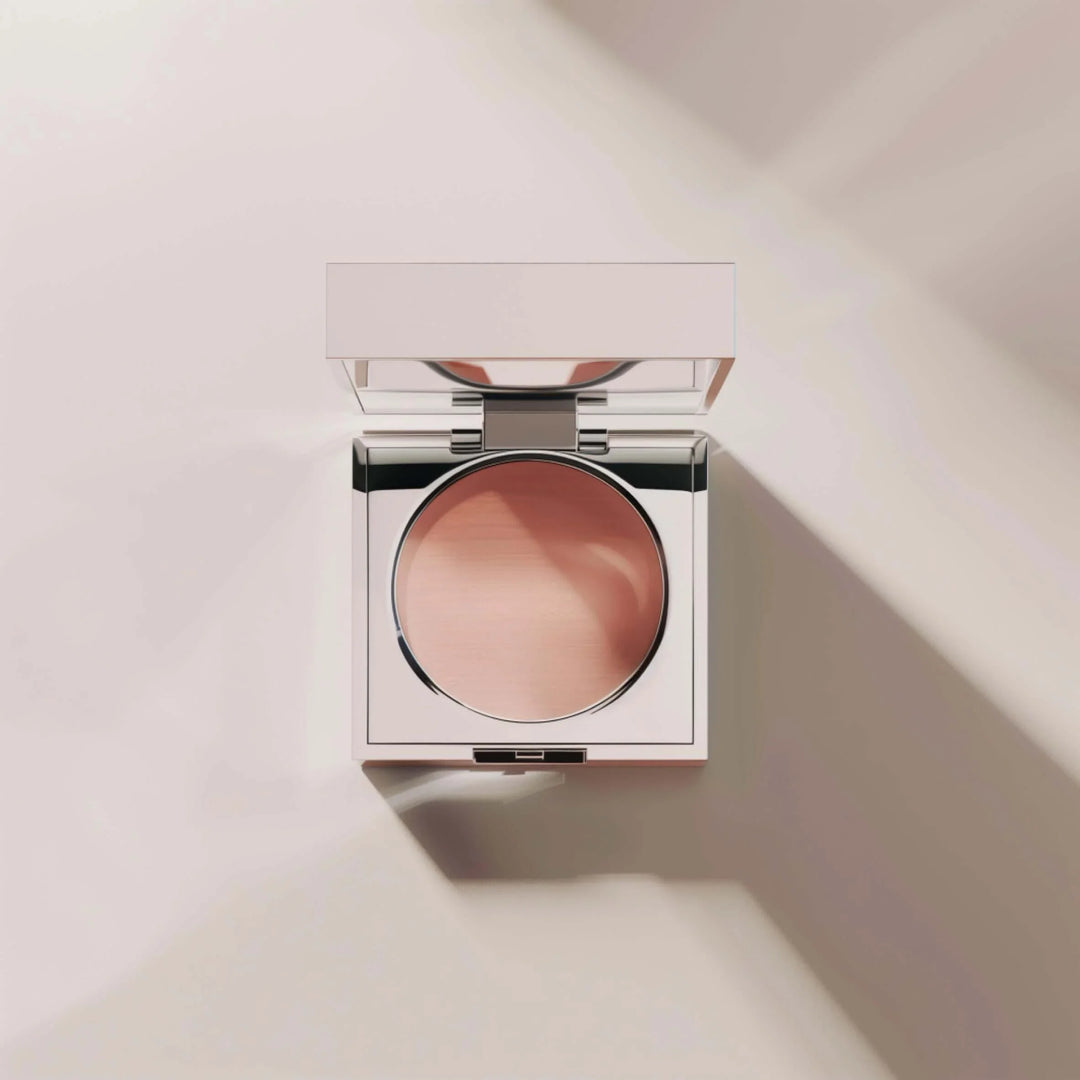 Minimalist compact makeup powder in sleek silver case with mirror on beige background