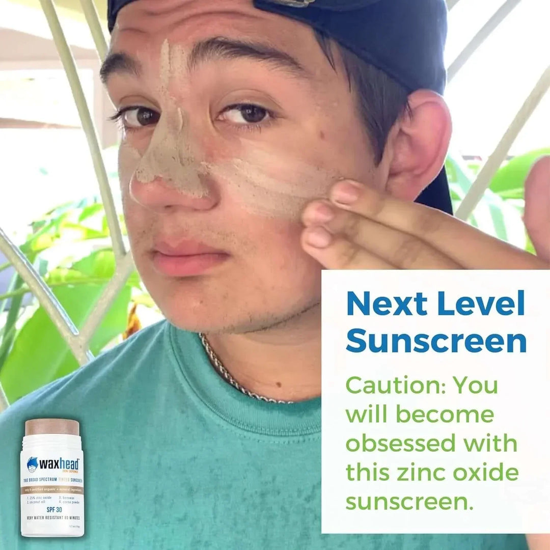 Young man applying zinc oxide sunscreen to face outdoors with waxhead SPF 30 stick visible