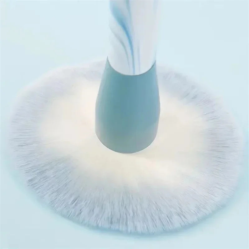 Close-up of a spinning white and blue electric cleaning brush with soft bristles on a light background
