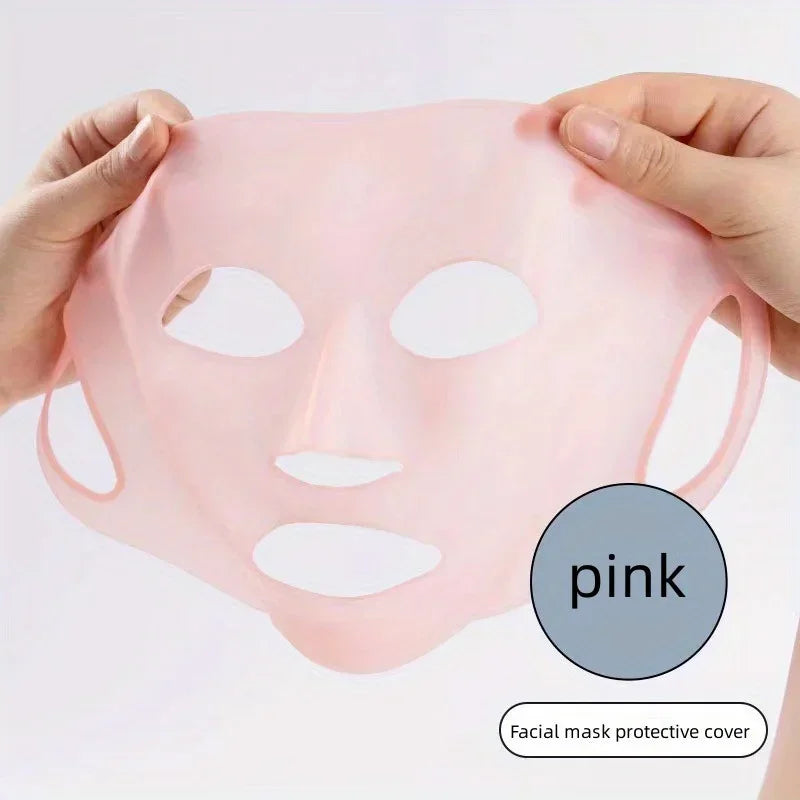 Hands holding a stretchable pink facial mask protective cover with cutouts for eyes, nose, and mouth