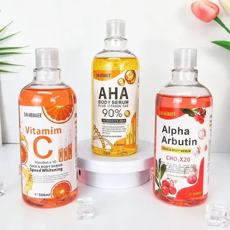 Dr. Meiniaer Vitamin C, AHA, and Alpha Arbutin face and body serums in transparent bottles with citrus and berry graphics