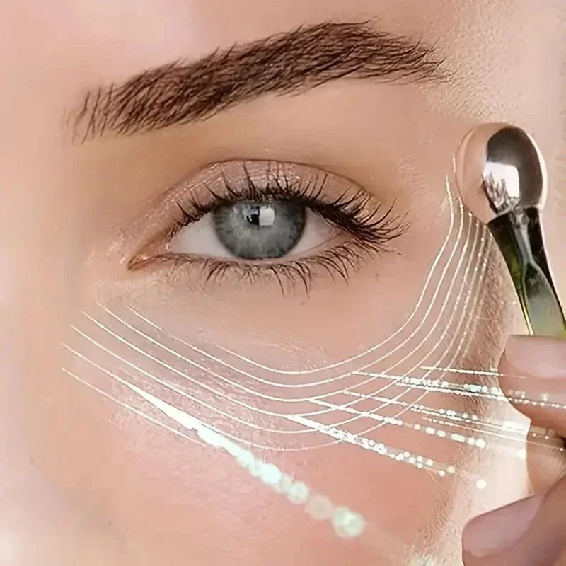 Close-up of blue eye with makeup brush applying cream under eye with glowing beauty lines