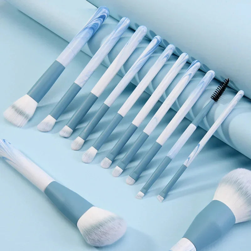 Set of blue and white marble handle makeup brushes on a light blue background