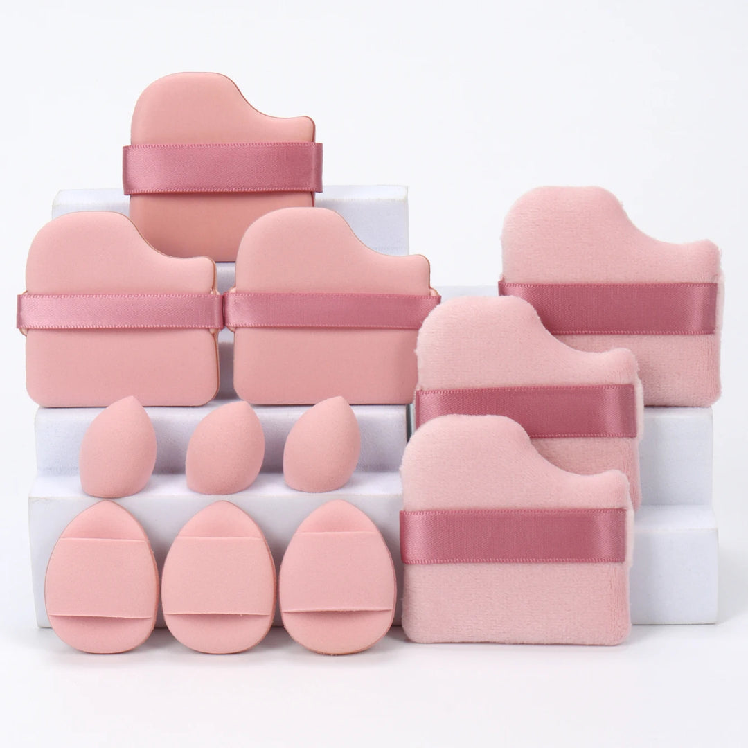 Set of soft pink makeup sponges and applicator pads with satin straps on white blocks