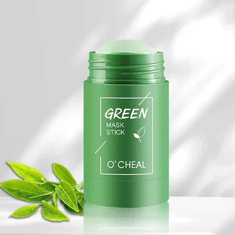 Green mask stick cosmetic product by O'Cheal with fresh green leaves on white background