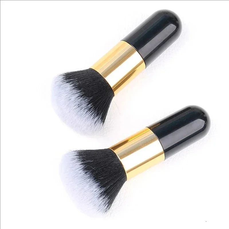 Two black and white bristle makeup brushes with shiny gold and black handles on white background