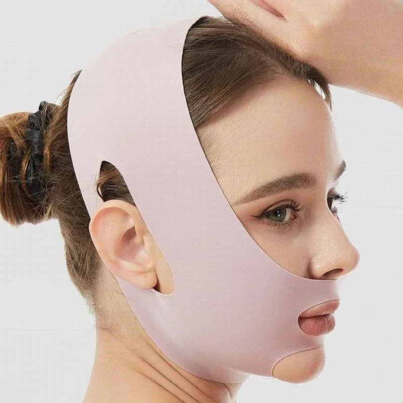 Woman wearing a light pink facial slimming strap lifting her hair, close-up side profile